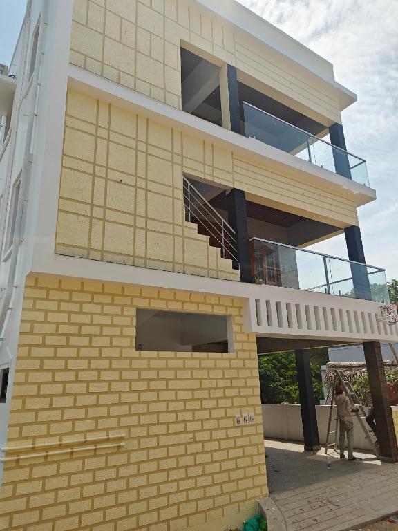 a person walking in front of a building at Treva Breeze Villa 2BHK in Kīl Kāsākkudi