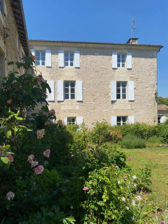 a large brick building with white windows and flowers at Le Clos de l'Herbaudière in Saivres