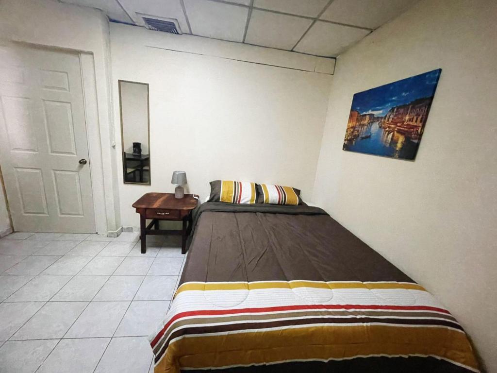 ein Schlafzimmer mit einem Bett und einem Tisch darin in der Unterkunft Hostal 5224 in San Salvador