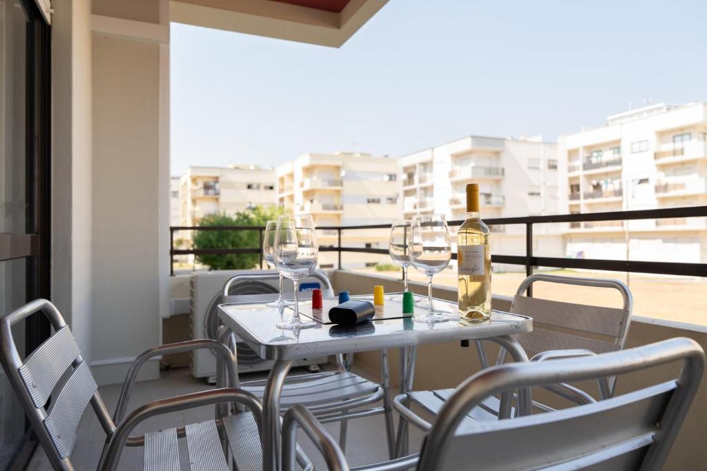 een tafel met wijnglazen op een balkon bij White Charm by the Sea in Viana do Castelo