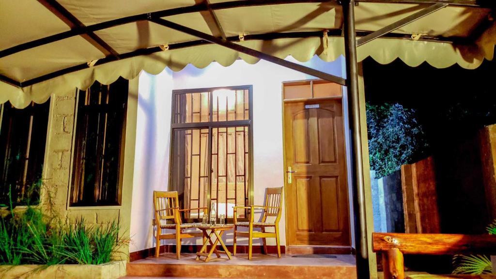 a patio with a table and chairs on a porch at Given House in Tuvaila