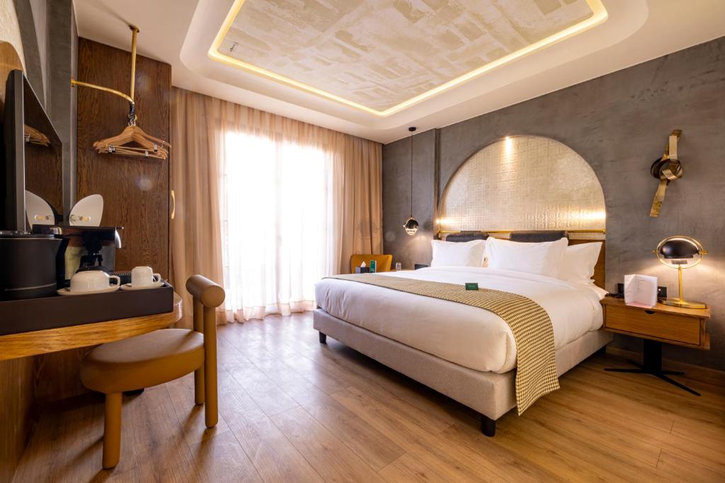 ein Schlafzimmer mit einem großen Bett und einem Schreibtisch sowie einem Bett von sidx sidx sidx sidx sidx in der Unterkunft Le Square By Onomo Collection in Casablanca