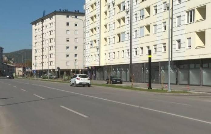un coche blanco conduciendo por una calle al lado de un edificio en Urban escape, en Doboj