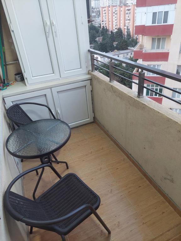 a table and a chair sitting on a balcony at Двушка для гостей in Baku
