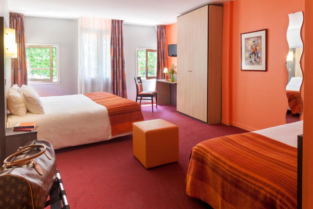 En eller flere senge i et værelse på BRIT HOTEL Le Lion d'Or CHINON