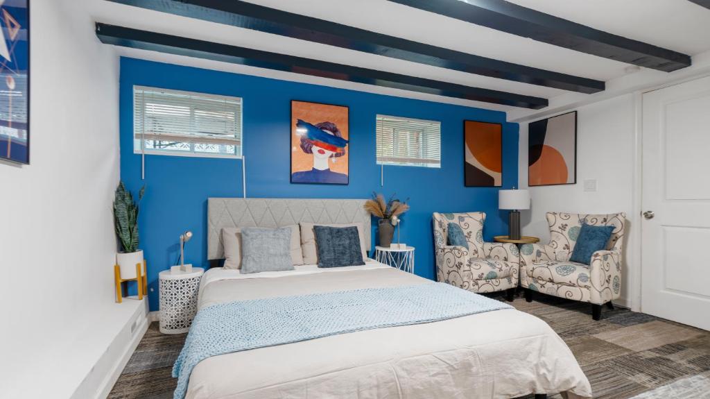 a blue bedroom with a bed and two chairs at 2 Bedroom Cozy Gem Manhattan Beach in Brooklyn