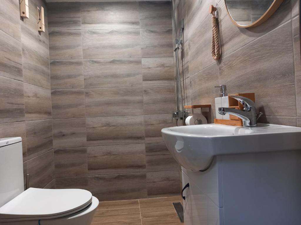 a bathroom with a sink and a toilet at Къща за гости Шанови in Gʼovren