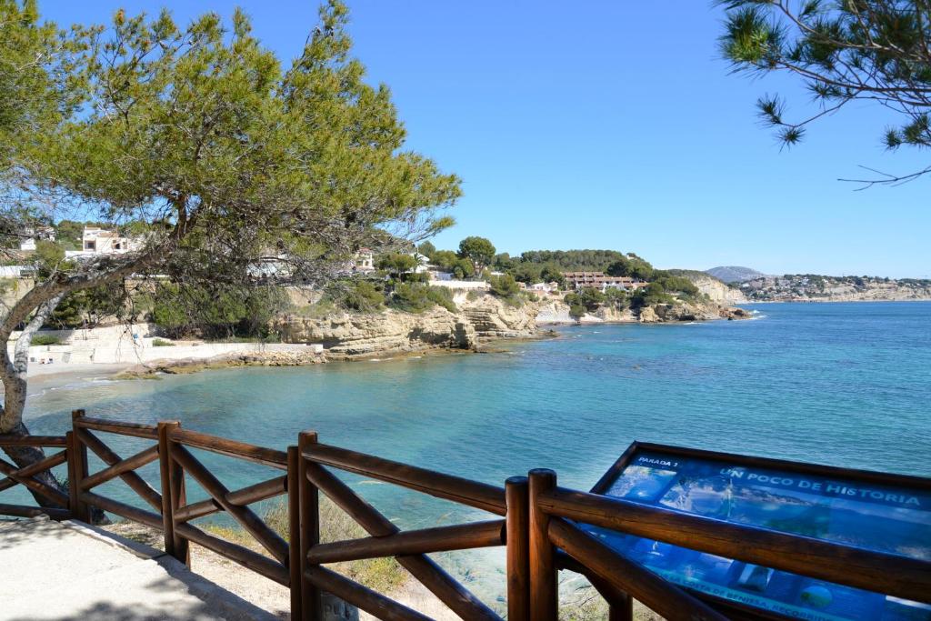 un ordenador portátil sentado en una valla junto a un cuerpo de agua en Hostal La Fonda Grupo Terra de Mar, alojamientos con encanto, en Benissa