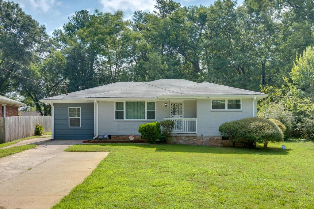 a white house with a porch and a yard at Inviting Home with Backyard 8 Mi to Dtwn Atlanta! in Atlanta