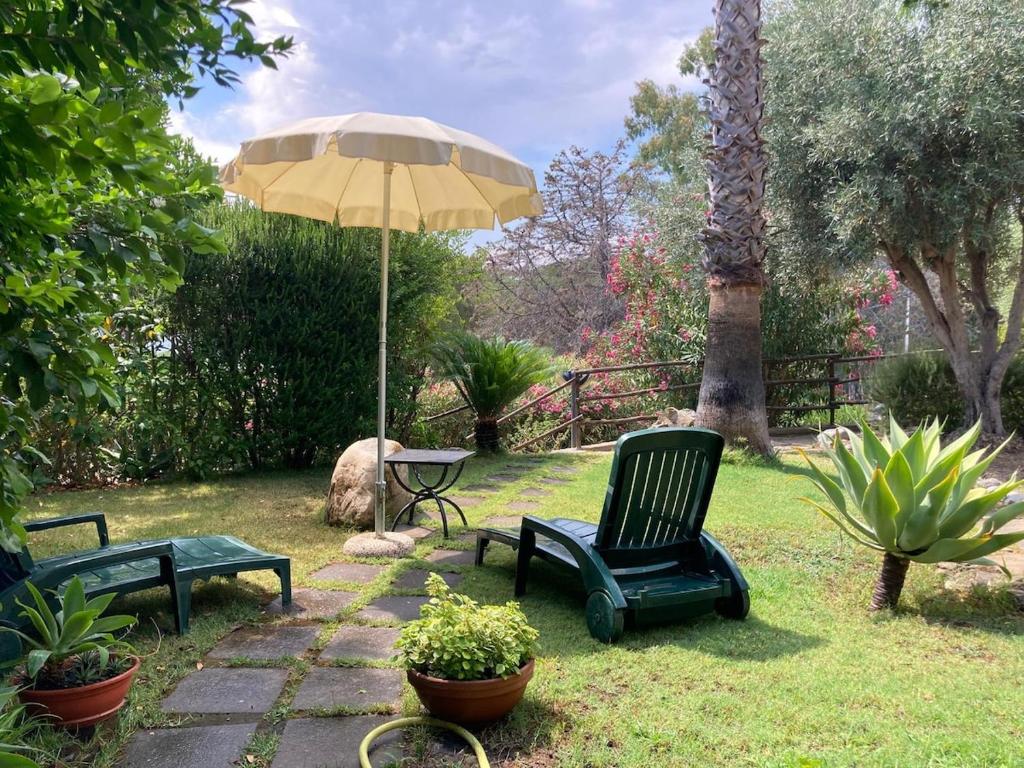 a patio with two chairs and an umbrella at Villa Ichnos South Sardinia IUN Q8503 in Quartu Sant'Elena