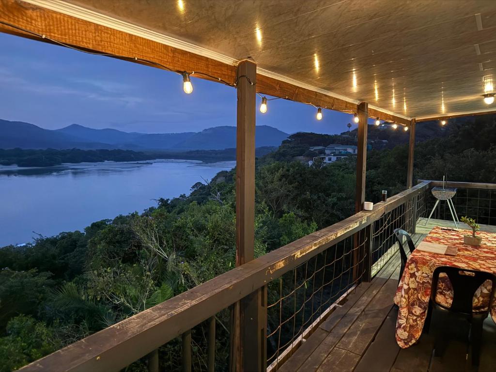 a deck with a table and a view of a river at Blue Lagoon 4x4 Cottage in Umngazana