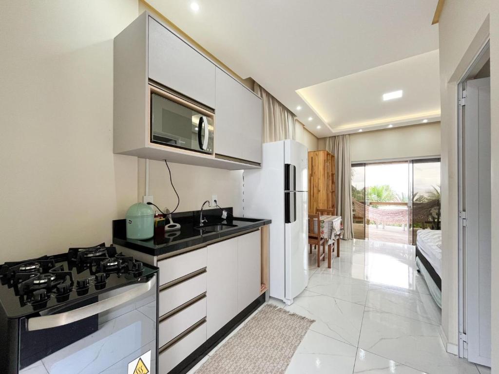a kitchen with a sink and a stove top oven at Loft Sol e Mar Exclusivo em Bombinhas 50m da praia in Bombinhas