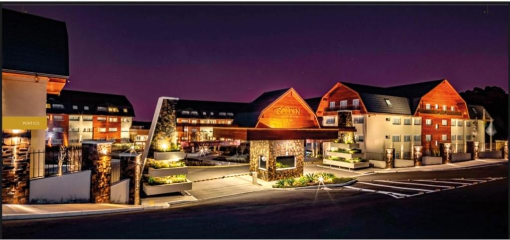 a group of buildings at night with lights at Quarto no Laghetto Golden Resort in Gramado