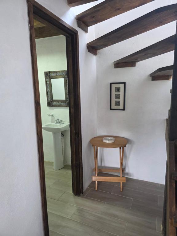 a bathroom with a table and a mirror and a sink at Cabañas Las orquídeas in Huasca de Ocampo