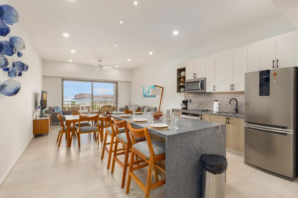 Una cocina con mesa y sillas y un refrigerador. en 2BR Summer Escape Villa in Danzante Bay Loreto, en Ensenada Blanca