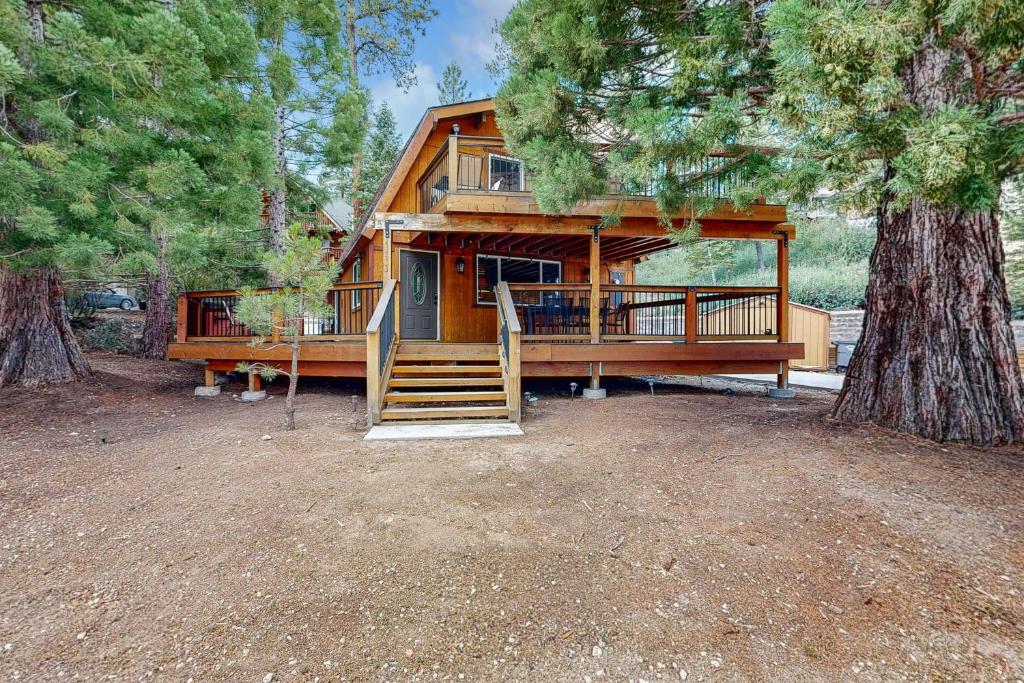 a large wooden cabin with a porch and a tree at Primrose Cabin #709 in Big Bear Lake