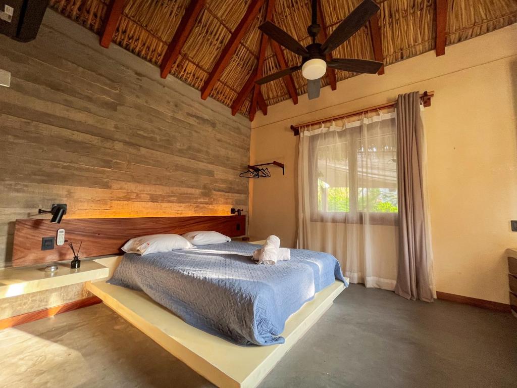 a bedroom with a bed with a wooden wall at Paraíso del Surf, A 50m de las Olas Perfectas, AC, Starlink, Piscina, La Saladita surf in La Salada