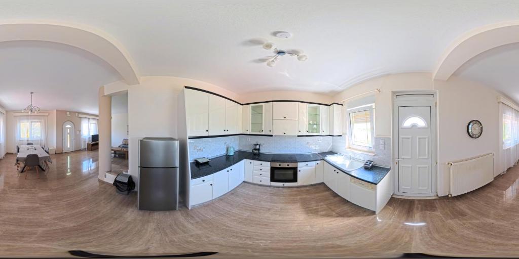 a large kitchen with white cabinets and blue counters at Villa Morfi 1 in Alexandroupoli