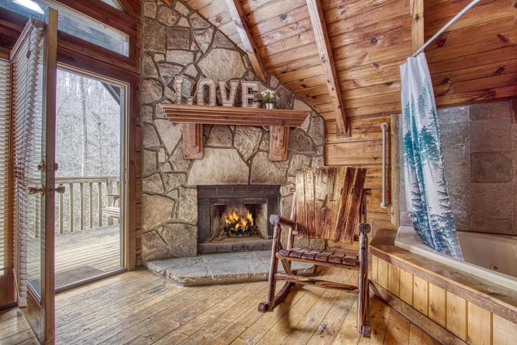 - un salon avec une cheminée et un fauteuil à bascule dans l'établissement Mountaintop Romance private 10 mins from Gat and PF, à Sevierville