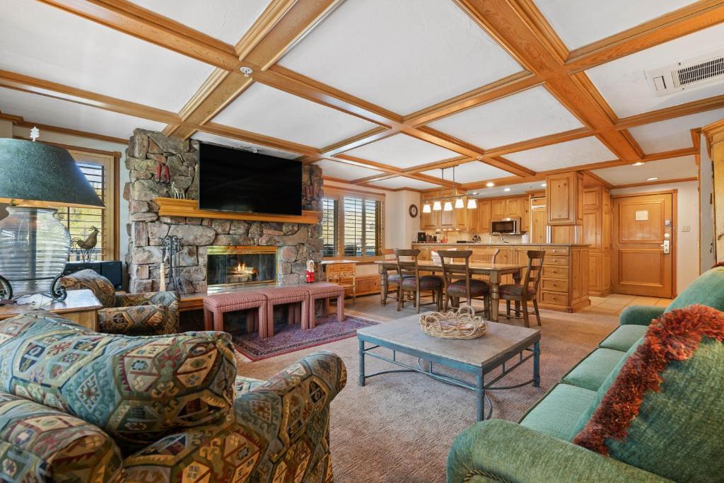 a living room with couches and a stone fireplace at Lodge Tower 599 One Bedroom Residence in Vail