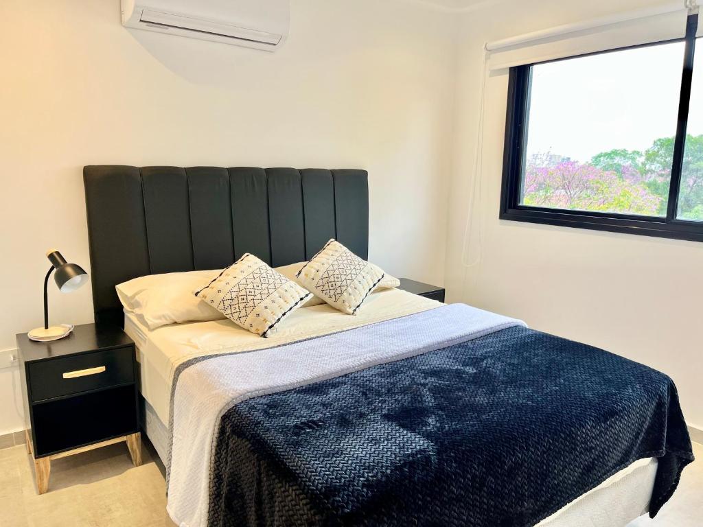a bedroom with a bed with a large window at Edificio Brooklyn in Asuncion