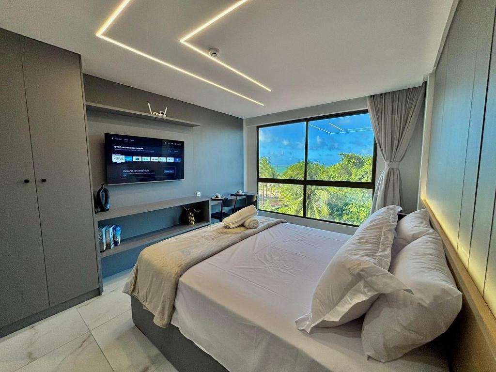 a bedroom with a large bed with a large window at DVA Cabedelo Beira-Mar – O Paraíso na Ponta de Cabedelo in Cabedelo