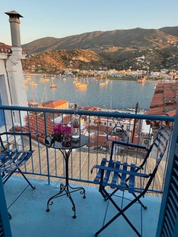 een balkon met twee stoelen en een tafel met bloemen bij Mona in Poros