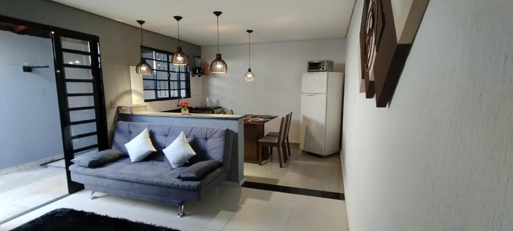 a living room with a blue couch and a kitchen at Casa aconchegante privativa in Limeira
