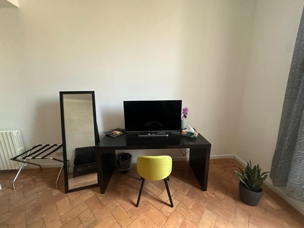 escritorio con espejo y silla amarilla en The APT 23 Tivoli, en Tívoli