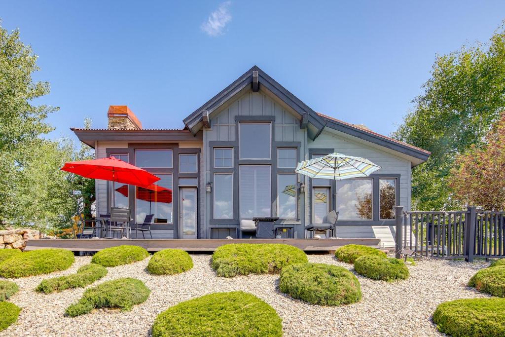 a house with a red umbrella and some bushes at Grand Elk Golf Club On-Site Mtn-View Home with Deck in Granby