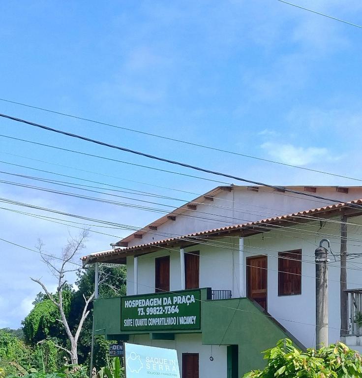 a building with a sign in front of it at Quarto Compartilhado na Praça de Serra Grande in Uruçuca
