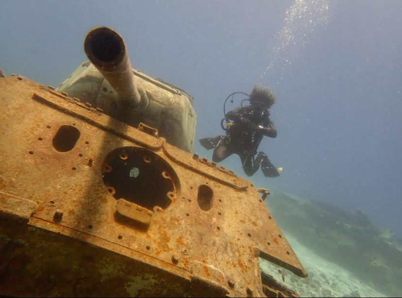 a person is standing next to an old tank at Private Diving in Hurghada in Hurghada