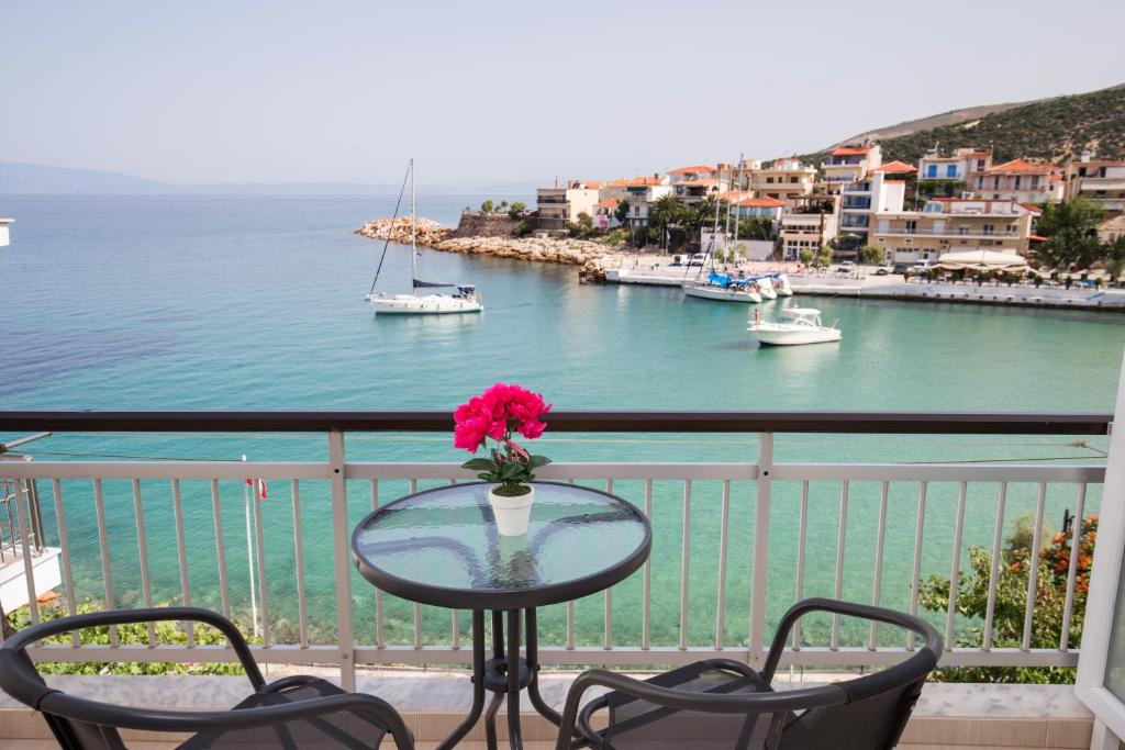 a table with a vase of flowers on a balcony at Aglaia Studios in Skala Marion