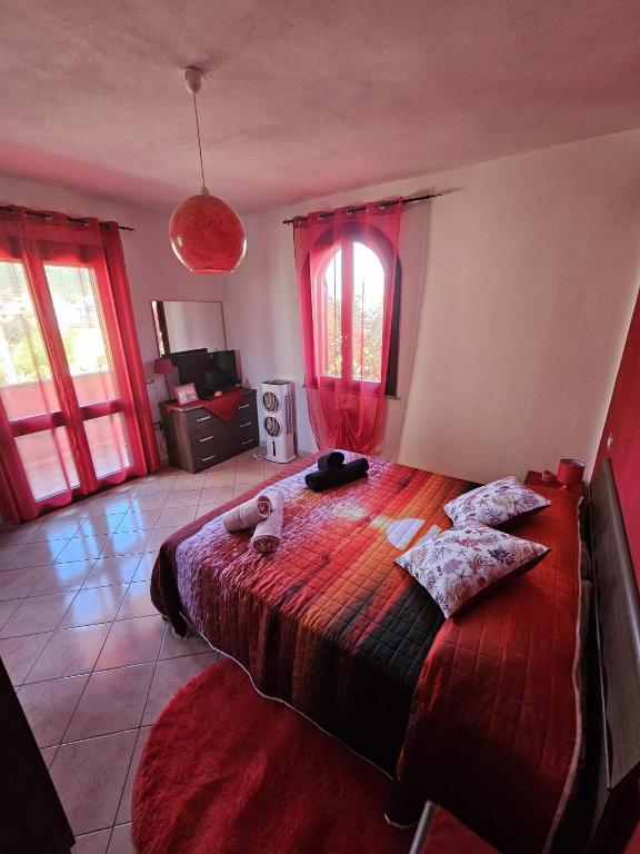 a bedroom with a large bed with red curtains at La Stella Marina in Bari Sardo