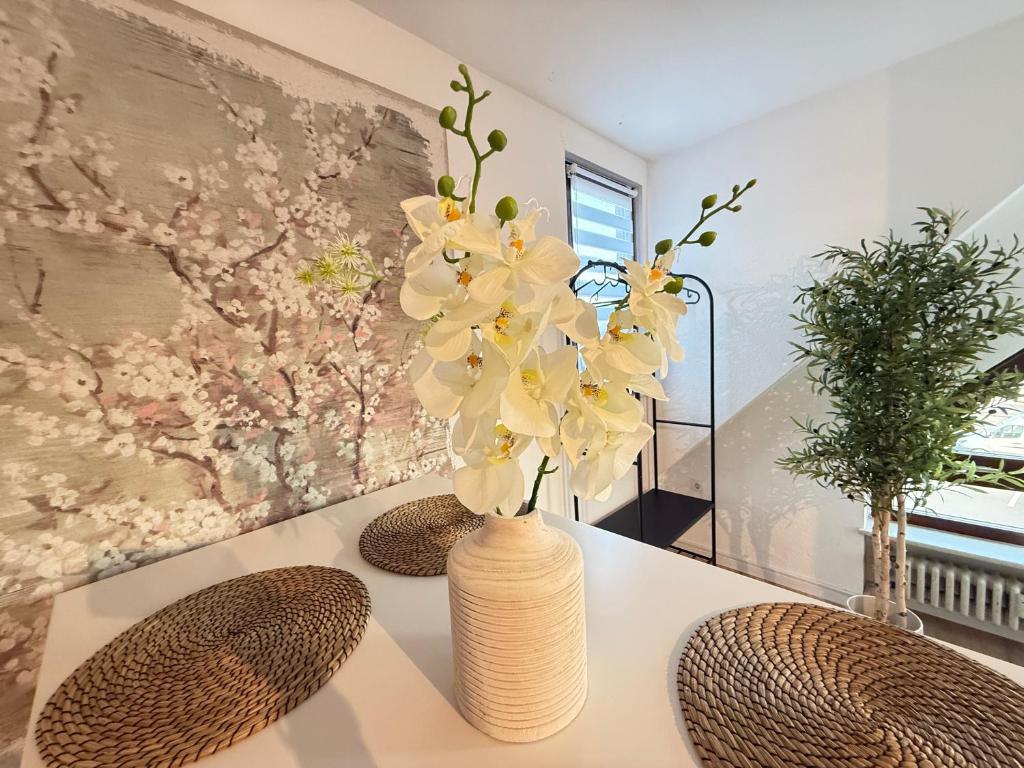 a vase with flowers in it sitting on a table at Ferienwohnung Stage One Zentrale Lage in Weißenthurm