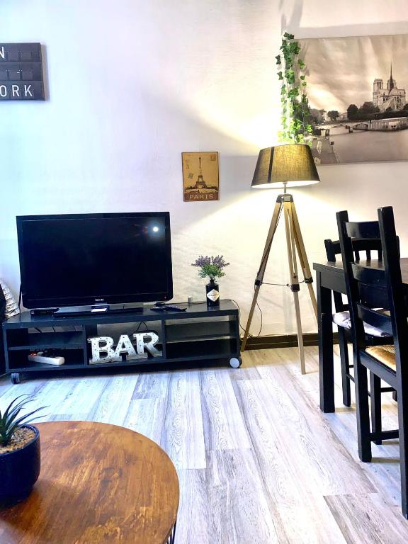 un salon avec une télévision à écran plat et une table dans l'établissement Appartements hyper Centre, à Carcassonne