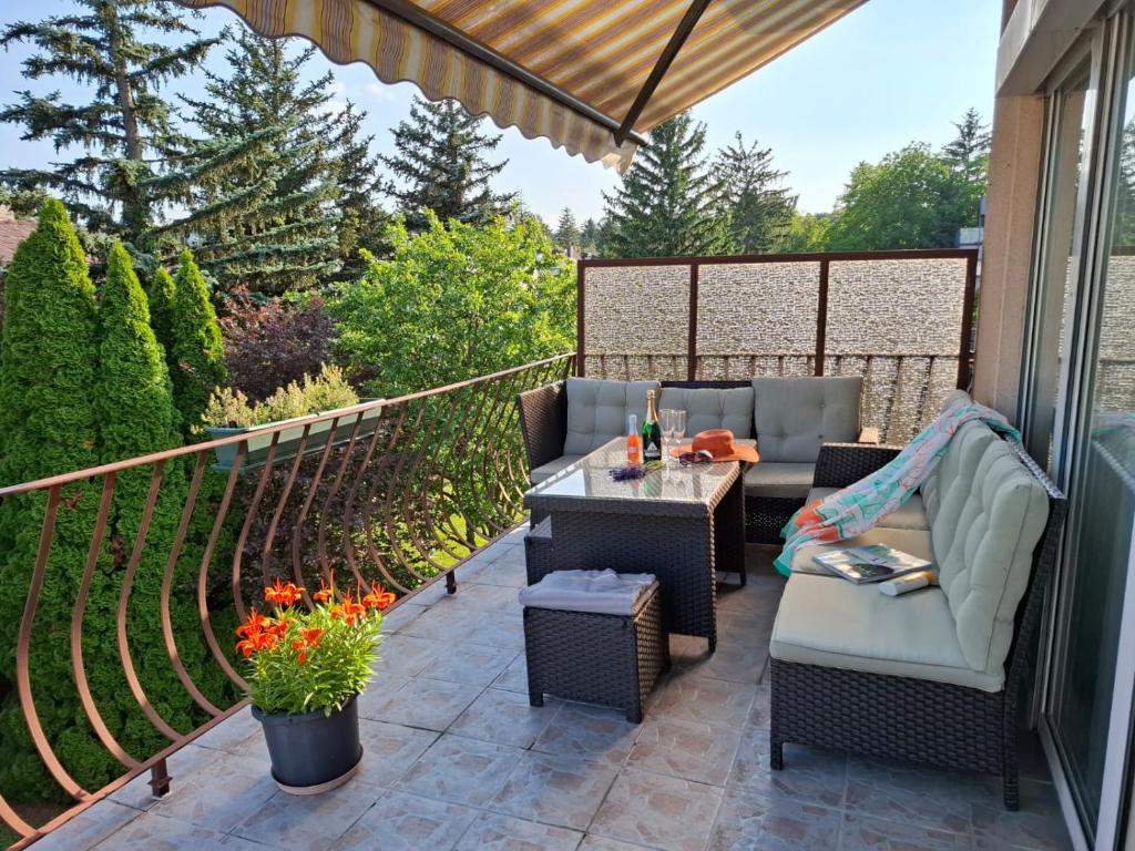 un patio avec des chaises et une table sur un balcon dans l'établissement Haabsburg Appartment Vienna 6 Personen, Balkon, voll ausgestattete Küche, Grün-Ruhelage am Stadtrand, gute Öffi Anbindung, à Vienne