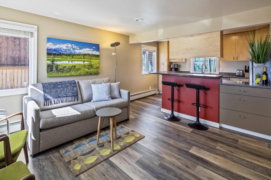 ein Wohnzimmer mit Couch und Küche in der Unterkunft Moose Meadow Cottage in Anchorage