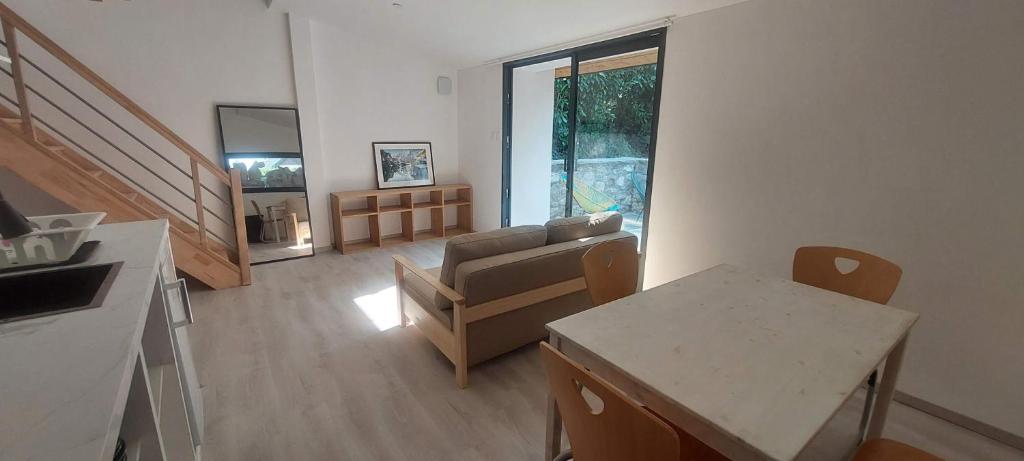 a living room with a couch and a table at APPARTEMENT 4 PERSONNES 100 metres du Lac jardin privé in Doussard