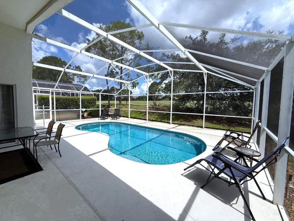 a patio with a swimming pool with chairs and a table at Southern Dunes - Golf Course Views Villa in Haines City
