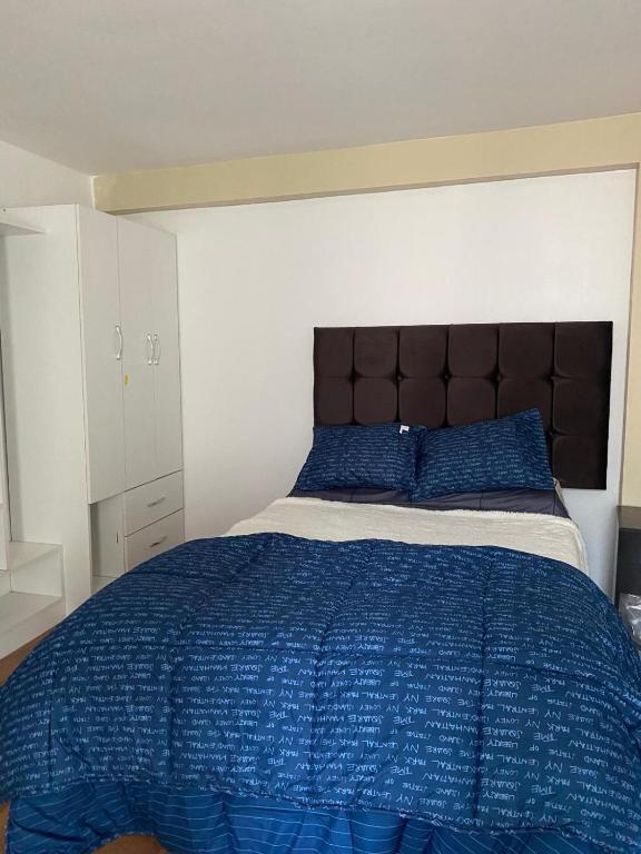 een slaapkamer met een bed met een blauw dekbed bij Killary in Urubamba