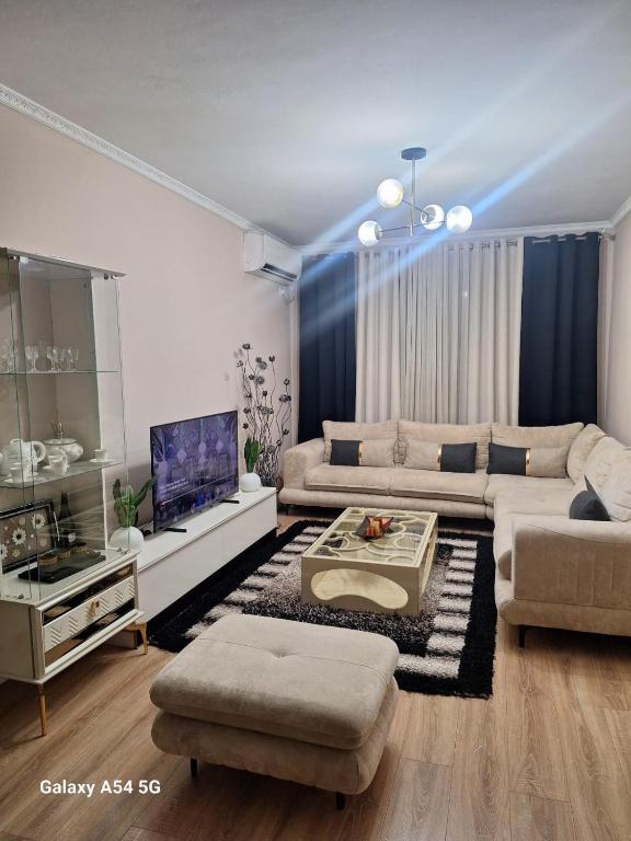 a living room with a couch and a tv at Best Apartment in Valjiosi