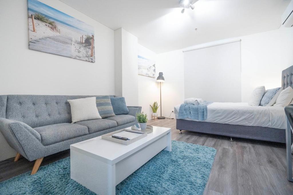 パースにある206 Funky Executive Studio Cbd Acのソファとベッドのあるリビングルーム