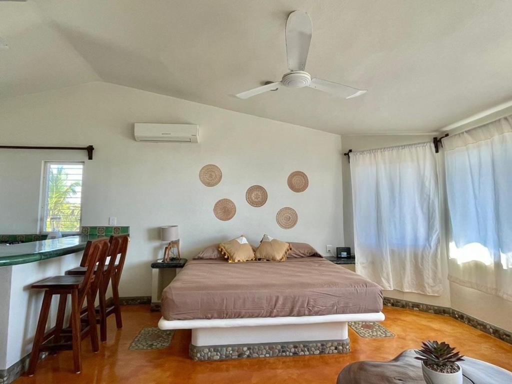 ein Schlafzimmer mit einem Bett und einem Tisch und Stühlen in der Unterkunft Casa de las Aves in Puerto Escondido