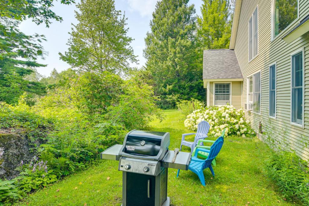 a bbq and two blue chairs in a yard at Rural Retreat 3 Mi to Morrisville and Rail Trail! in Hyde Park