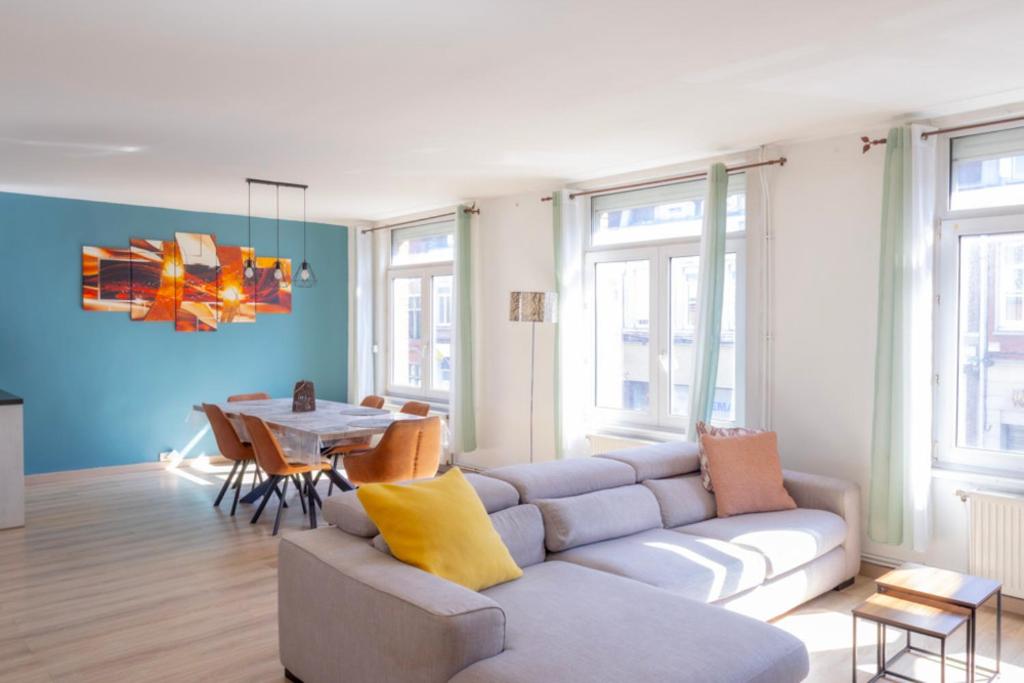 un soggiorno con un divano e un tavolo di Appart 10 pers - Lille Lambersart - Parking & Terrasses a Lambersart