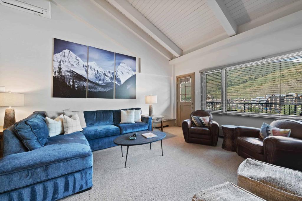 a living room with a blue couch and chairs at Lodge Tower 786 Two Bedroom Residence in Vail
