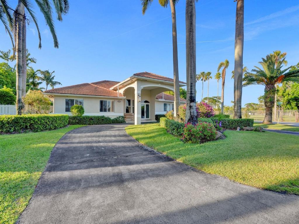 a house with palm trees and a driveway at Casa Fina Miami Near Beaches 