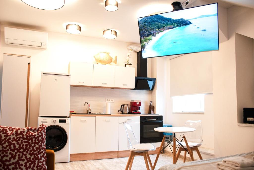 a kitchen and living room with a tv on the wall at Six Lamps on Masarykova in Zagreb