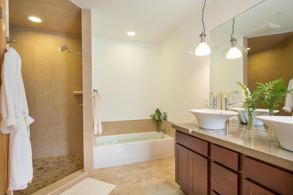 Darien的住宿－River Spring Lodge，浴室配有2个盥洗盆、浴缸和淋浴。